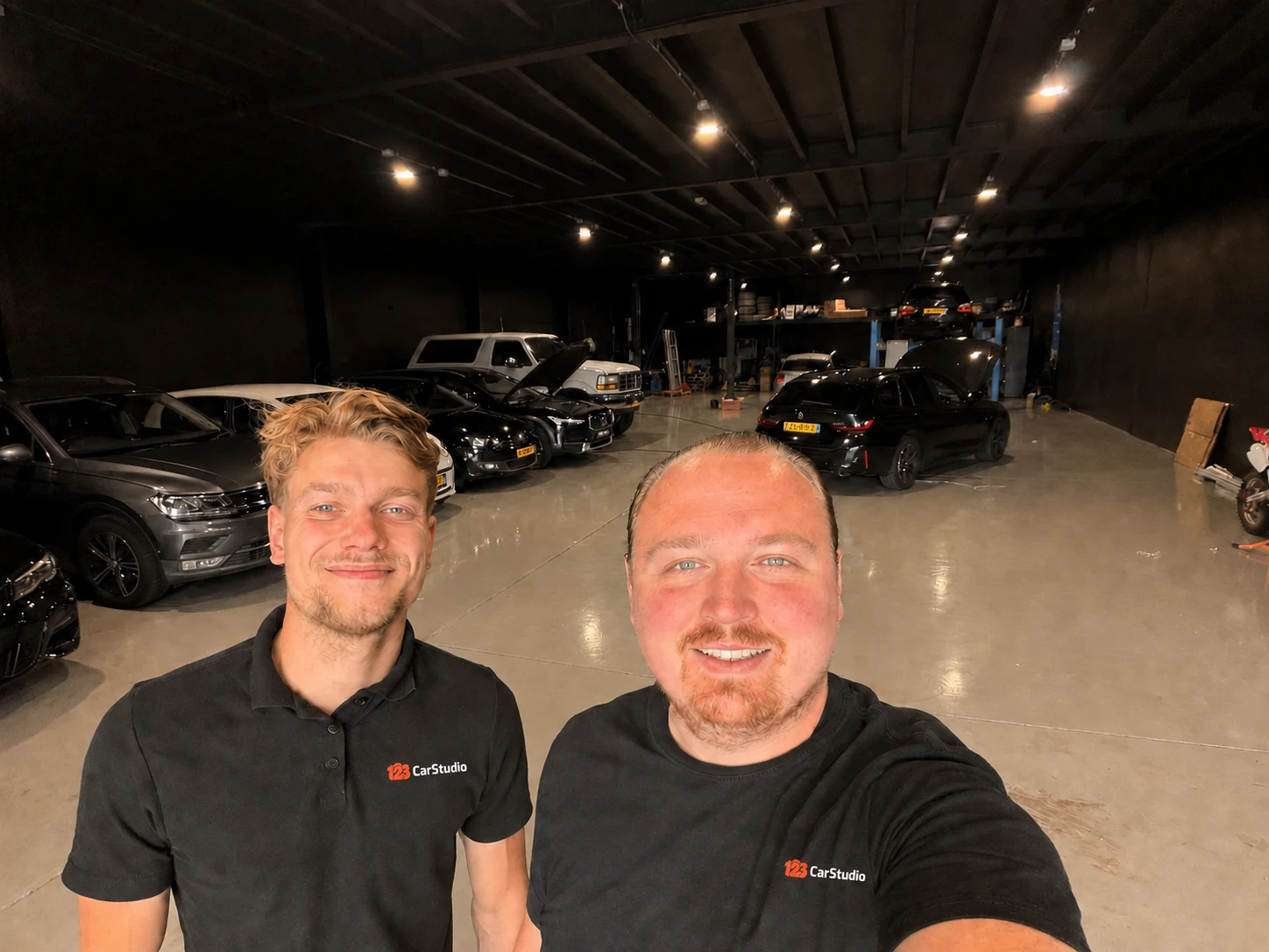 Pepijn Noort en Dylano Mulder in de werkplaats, met 123CarStudio op hun shirts